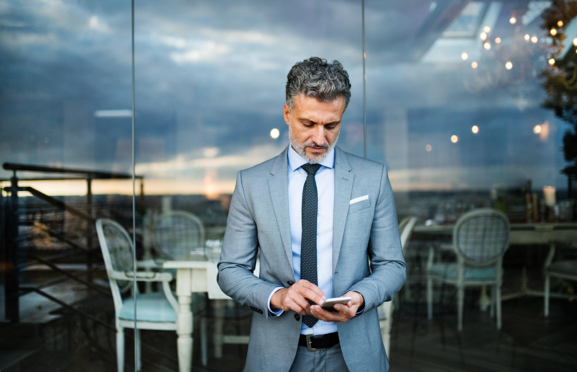 A business person looks down at their phone.