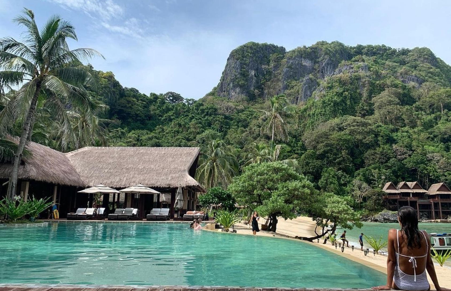 A person sits on the edge of the pool.