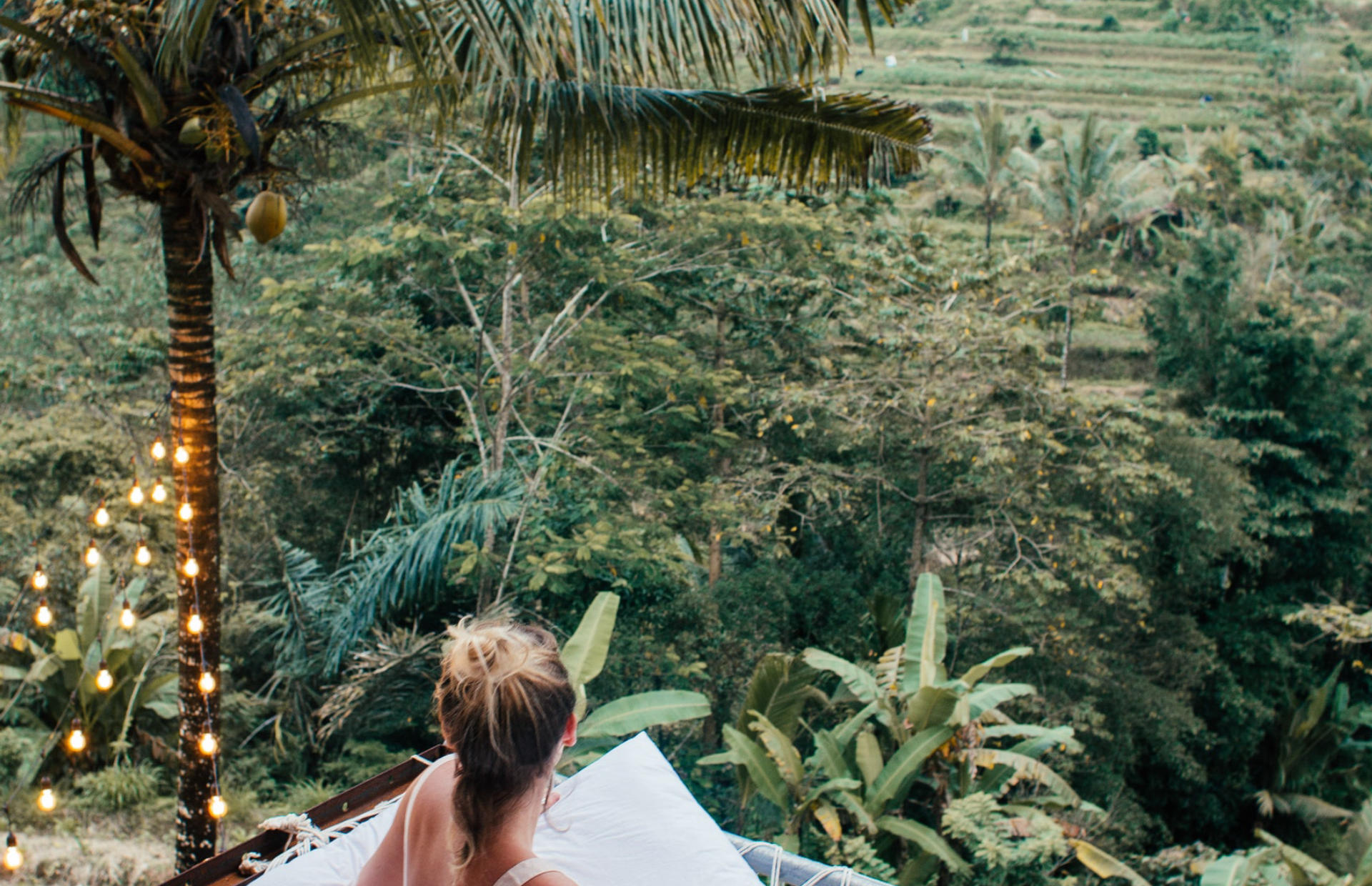 A hotel guest looks out into the forest below.